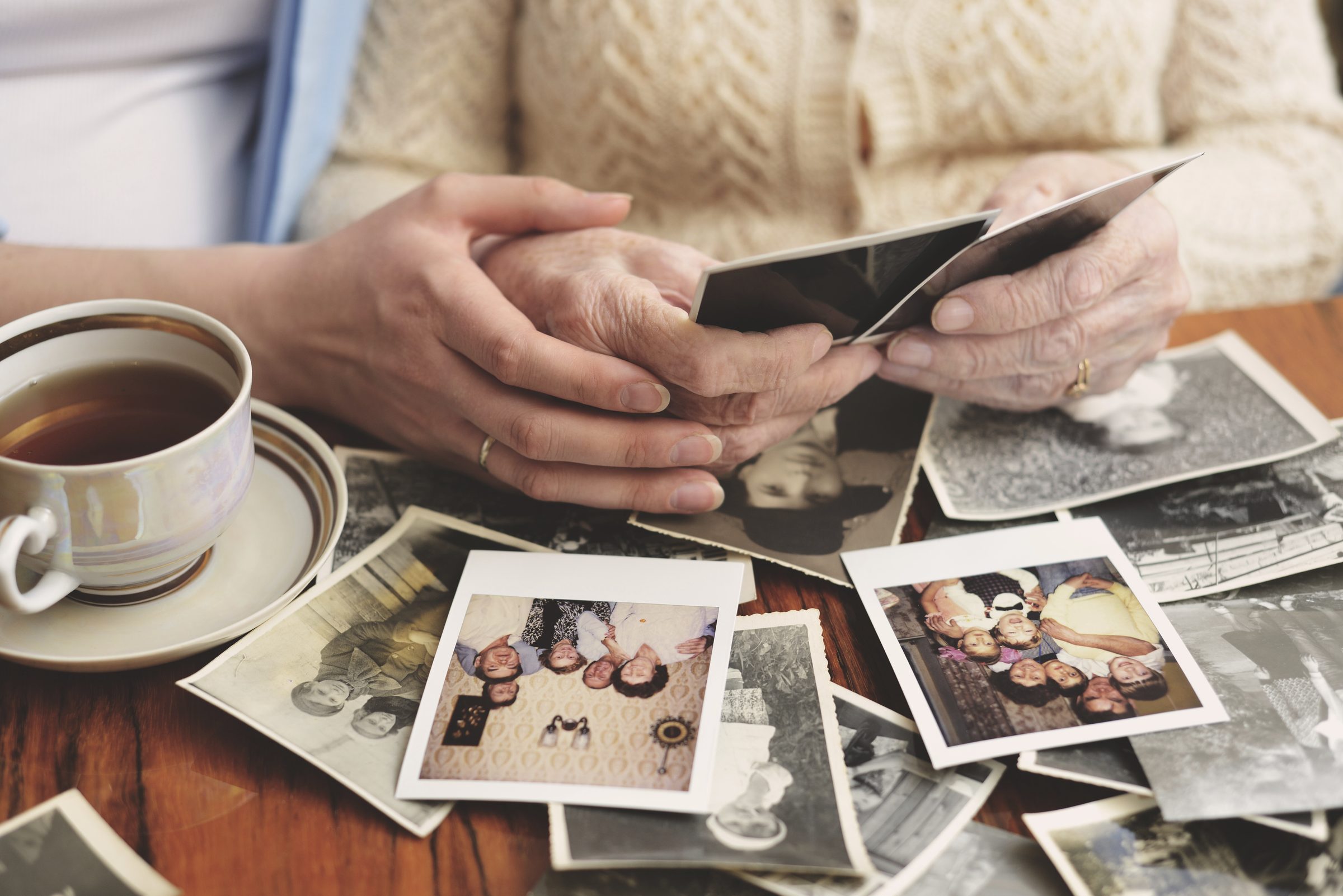 Mãos segurando fotos antigas de família